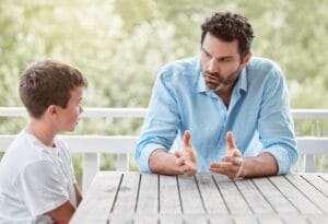 Padre de familia conversando con su hijo sobre convivencia escolar en Perú