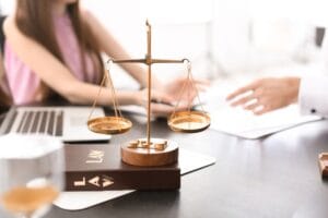 Balanza de la justicia junto a un contrato de matrícula escolar en Perú