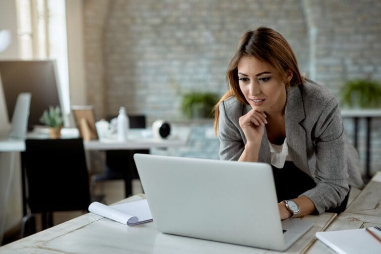Directora de colegio privado revisando el estado de cuenta de pensiones atrasadas en una laptop